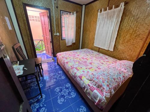 苏梅岛Wish Bungalow的一间卧室配有一张床、一张桌子和一个窗户。
