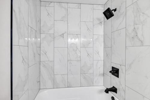 绿湾Hazelwood Haven near Lambeau! Duplex的浴室设有白色大理石瓷砖和淋浴。