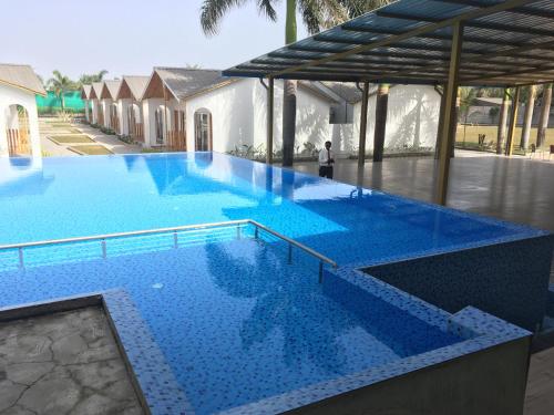 达曼VITS Daman Devka Beach的一座蓝色瓷砖的大型游泳池