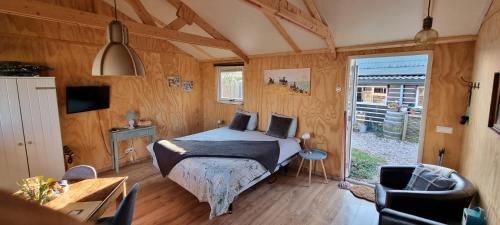 OostwoudB&B ZusenZomer的卧室配有一张床铺,位于带木墙的房间内