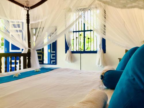 贝鲁沃勒Sriyan Villa的卧室配有带白色窗帘的床和窗户。