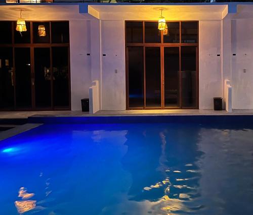 ZambalesLaZerena Lodge的夜晚有蓝色游泳池的房子