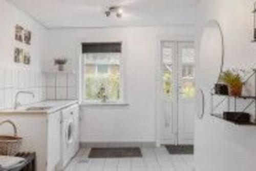 SpottrupVidunderligt hus i landlige omgivelser的白色的厨房设有水槽和浴缸。