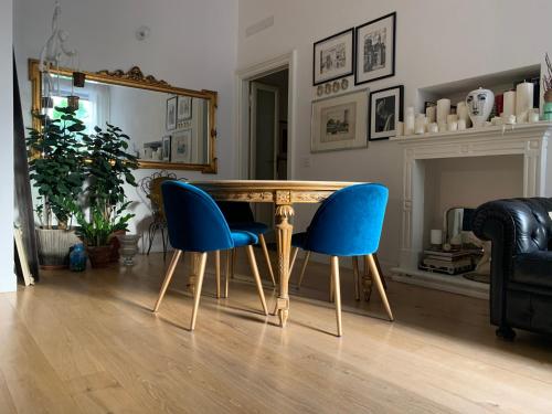米兰Bohemian House的一间带木桌和蓝色椅子的用餐室