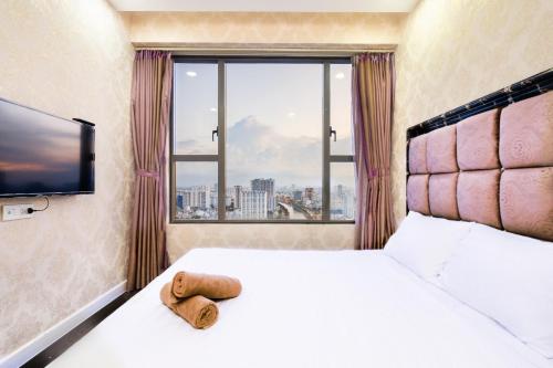 胡志明市Genius Apartment RiverGate Free Pool的酒店客房设有一张床和一个大窗户