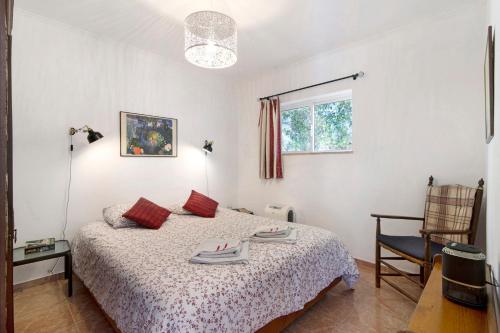 圣巴托洛梅乌迪梅西尼什Casa Arcadia T3的一间卧室配有一张床和一把椅子