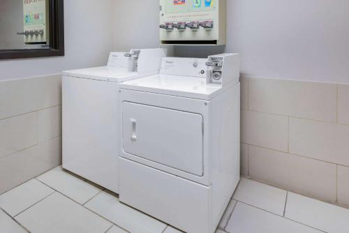 利格城Super 8 by Wyndham League City Kemah Area的浴室内提供白色洗衣机和烘干机