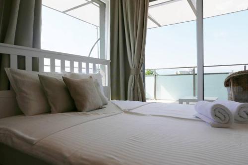 普罗夫迪夫Charmful new flat with Hill view的卧室配有带白色枕头的床和窗户。