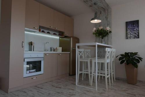 普罗夫迪夫Charmful new flat with Hill view的一间厨房,里面配有白色的凳子和一张桌子