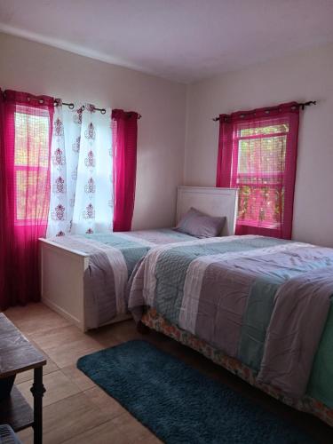 Sandy Point TownTeverence的一间卧室设有两张床和红色窗帘