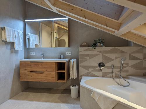 施万高ApartSchön的带浴缸、水槽和镜子的浴室