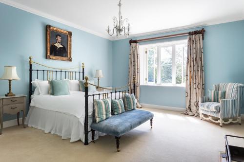 柯比朗斯代尔The Casterton Grange Estate的卧室拥有蓝色的墙壁,配有一张床和椅子