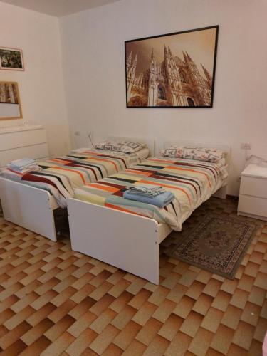 米兰Flat in Milan 3的卧室内配有两张单人床,墙上挂着一幅画