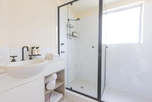布里斯班Selina Brisbane的白色的浴室设有水槽和淋浴。