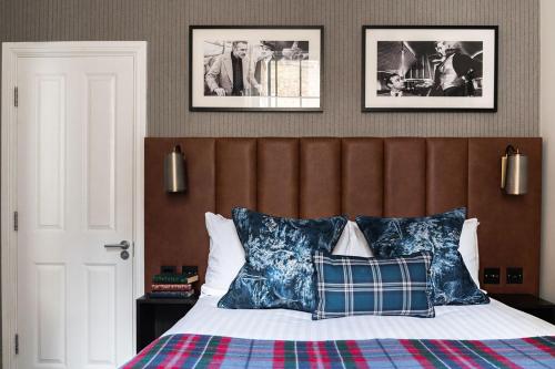 伦敦托普汉姆斯酒店的卧室配有一张墙上有两张照片的床。
