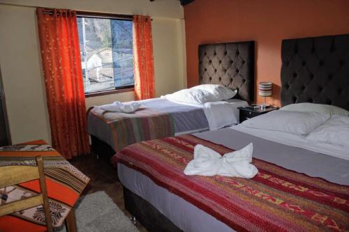 奥兰太坦波hostal Qorisonqo inn ollantaytambo的酒店客房设有两张床和窗户。