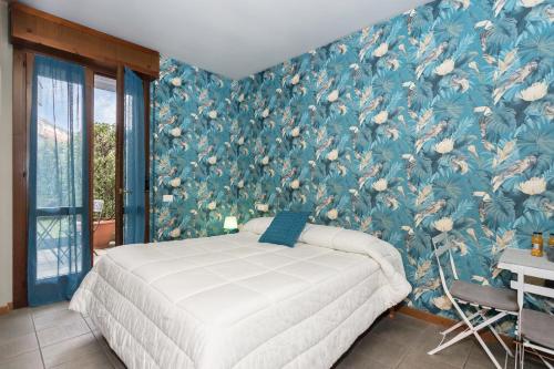 贝加莫伊尔菲欧雷住宅酒店的一间卧室配有一张蓝色花卉壁纸的床