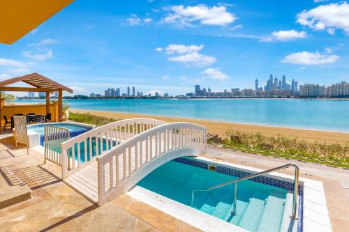 迪拜FAM Living - Palm Jumeirah - Beach Villas with Private Pool的一座游泳池,上面有一座桥,横跨水体