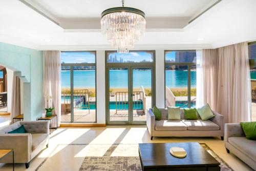 迪拜FAM Living - Palm Jumeirah - Beach Villas with Private Pool的带沙发和吊灯的客厅