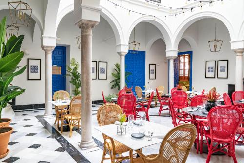 塞维利亚Vincci Molviedro的大楼内一家餐厅,配有红色的桌椅