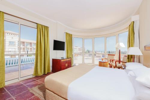 艾因苏赫纳Coral Sea Beach and Aqua Park的酒店客房设有一张床和一个大窗户