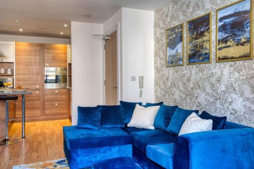 曼彻斯特City Centre Apartment - Ideal for longer stays的客厅设有蓝色沙发,配有厨房
