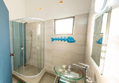 蓬塔杜欧鲁Ponta Mar Resort的一间带玻璃水槽和淋浴的浴室