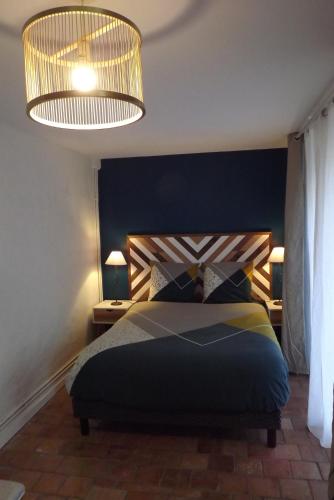 索米尔Chambres d'hôtes La Tour de Bellevue的一间卧室配有一张带蓝色床头板的床和两盏灯。