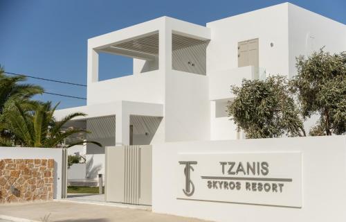 斯基罗斯岛Tzanis Resort Skyros的白色的建筑,带有tams sydney的夜间标志