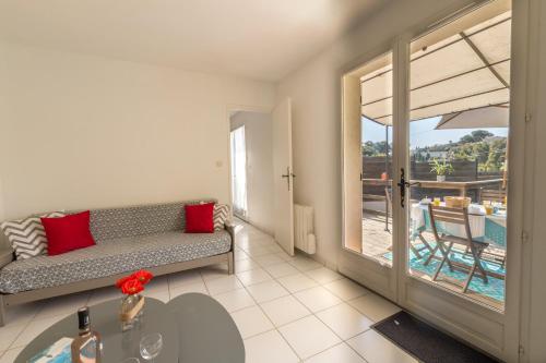 耶尔Le Verger, villa lumineuse et agréable avec son espace extérieur clos au cœur de notre vignoble的带沙发的客厅,享有游泳池的景色
