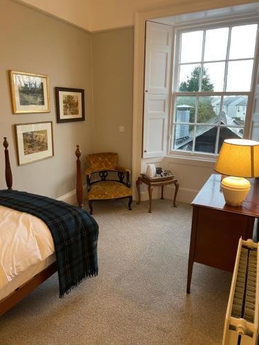 柯库布里The Garret Hotel的卧室配有床、椅子和窗户。