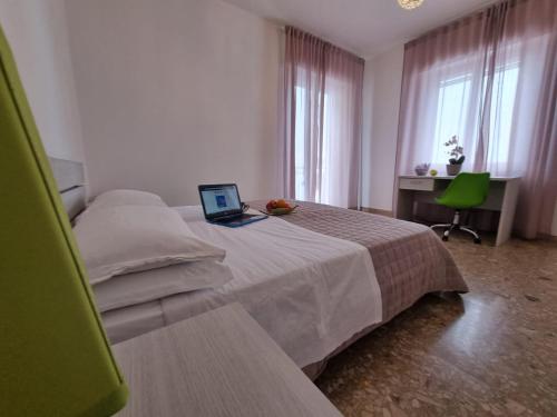 圣马力诺Appartamento al Centro Storico di San Marino的一间卧室配有一张带笔记本电脑的床