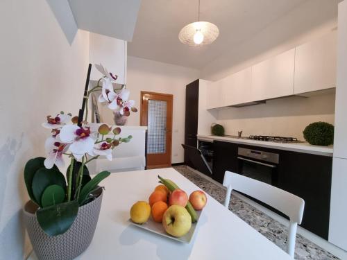 圣马力诺Appartamento al Centro Storico di San Marino的厨房配有带水果和鲜花的桌子