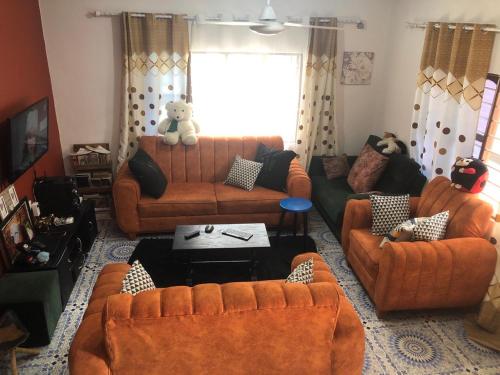 Kiembi SamakiAnayah House的客厅配有橙色的沙发和沙发上的泰迪熊