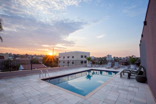 里奥韦尔迪Gelps Hotel的一座享有日落美景的建筑屋顶上的游泳池