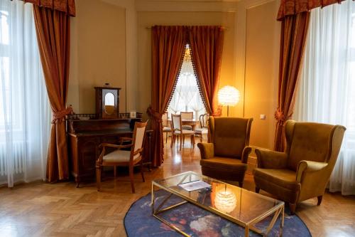 Wojanów帕拉斯沃间诺酒店的客厅配有三角钢琴和椅子