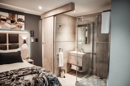 内尔斯普雷特Cascades Guest Lodge的一间卧室设有淋浴、一张床和一个水槽。