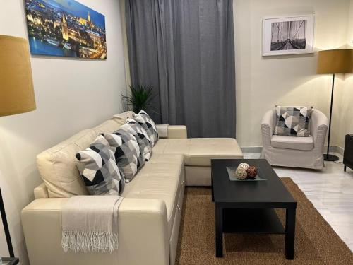 塞维利亚Apartamento Fibes-Congresos Parking Gratis的客厅配有白色的沙发和桌子