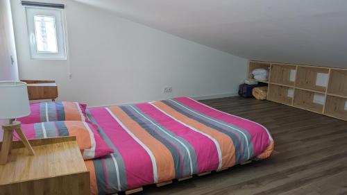 VillelaureAdorable petite maison au coeur du Luberon的一间卧室配有一张带彩色条纹被子的床
