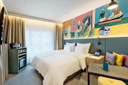 维也纳BASSENA Wien Donaustadt的酒店客房设有一张大床和一张沙发。