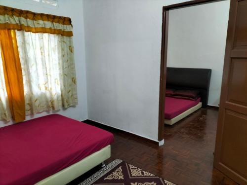 Kampong Parit TengahD'Aman Guesthouse Pontian的一间卧室配有两张床和镜子