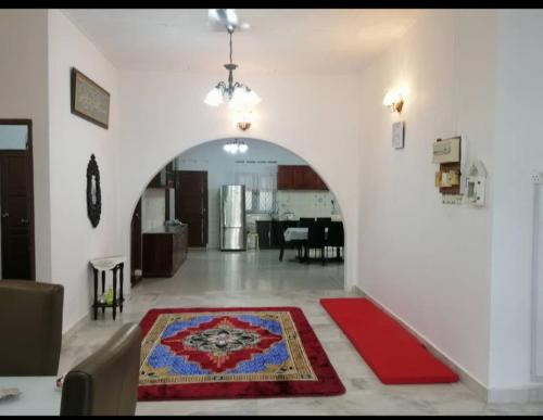 Kampong Parit TengahD'Aman Guesthouse Pontian的一间设有拱门和红色地毯的客厅