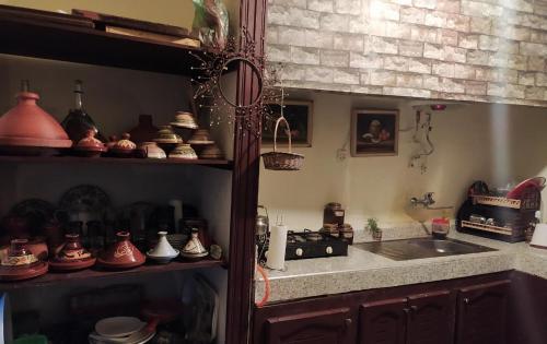 BhalilGrotte Thami的厨房配有水槽和带锅碗瓢盆的台面