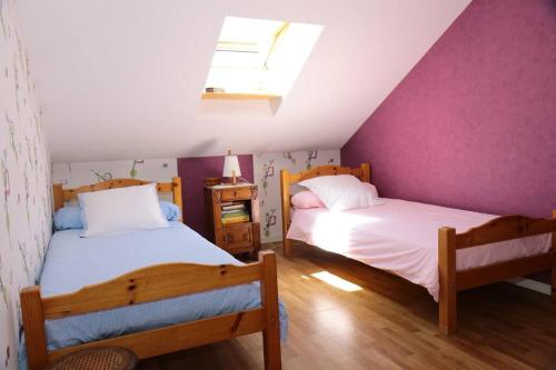 莱萨布勒-多洛讷La Rose des Sables maison de pêcheur de 7 pers.的阁楼卧室设有两张床铺和紫色墙壁