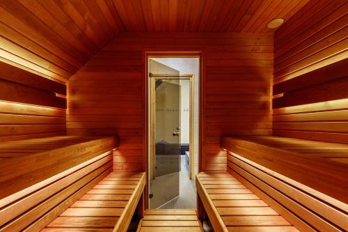 KülitseAida Apartment的一间铺有木地板的桑拿浴室,设有木墙