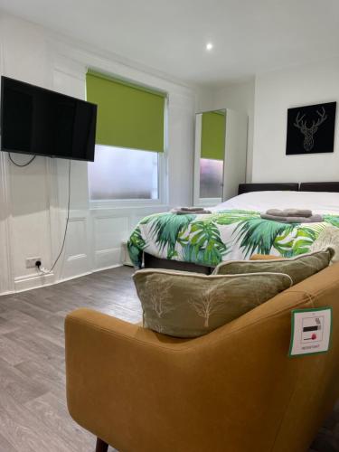 伦敦米尔德梅路公寓的一间卧室配有一张床、一张沙发和一台电视。