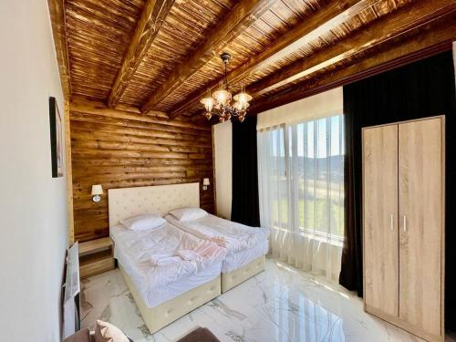 多斯帕特Villa ART的一间卧室设有一张木天花板床。