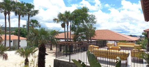 皮雷诺波利斯Resort Quinta Santa Barbara 18 a 24 Agosto的庭院里种有棕榈树,设有黄色椅子