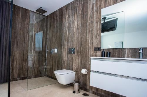 科斯塔特吉塞Golf Palms的一间带卫生间和淋浴的浴室以及一台电视。