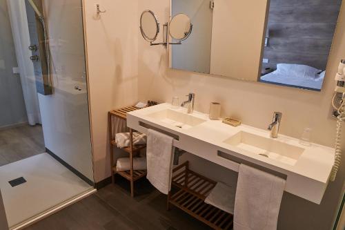 厄尔·波普瑙·德尔·戴尔三角洲拉尔加迪尔酒店的一间带水槽、镜子和淋浴的浴室